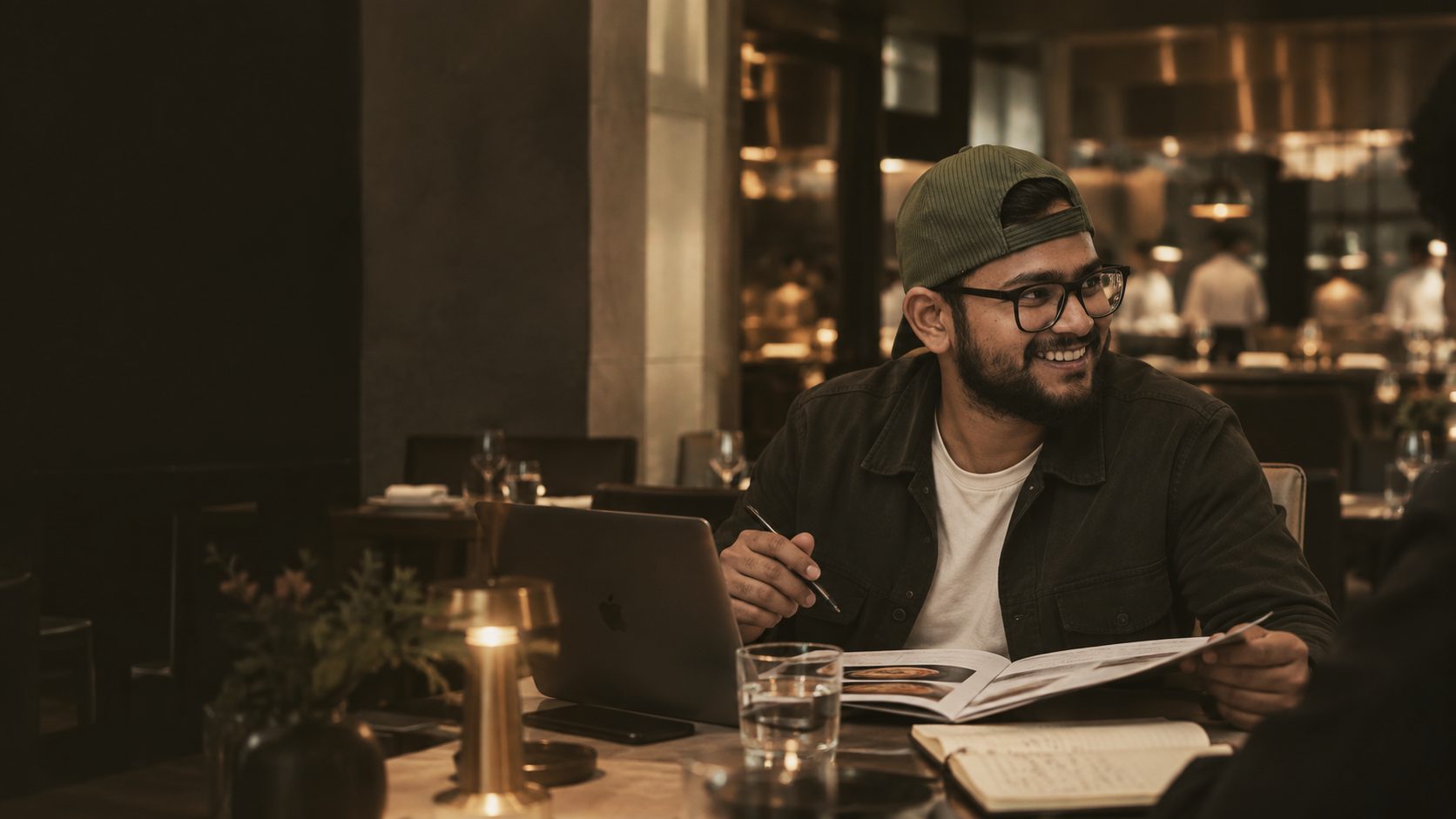 Piyush Raikwar reviewing a menu at a candlelit restaurant table.